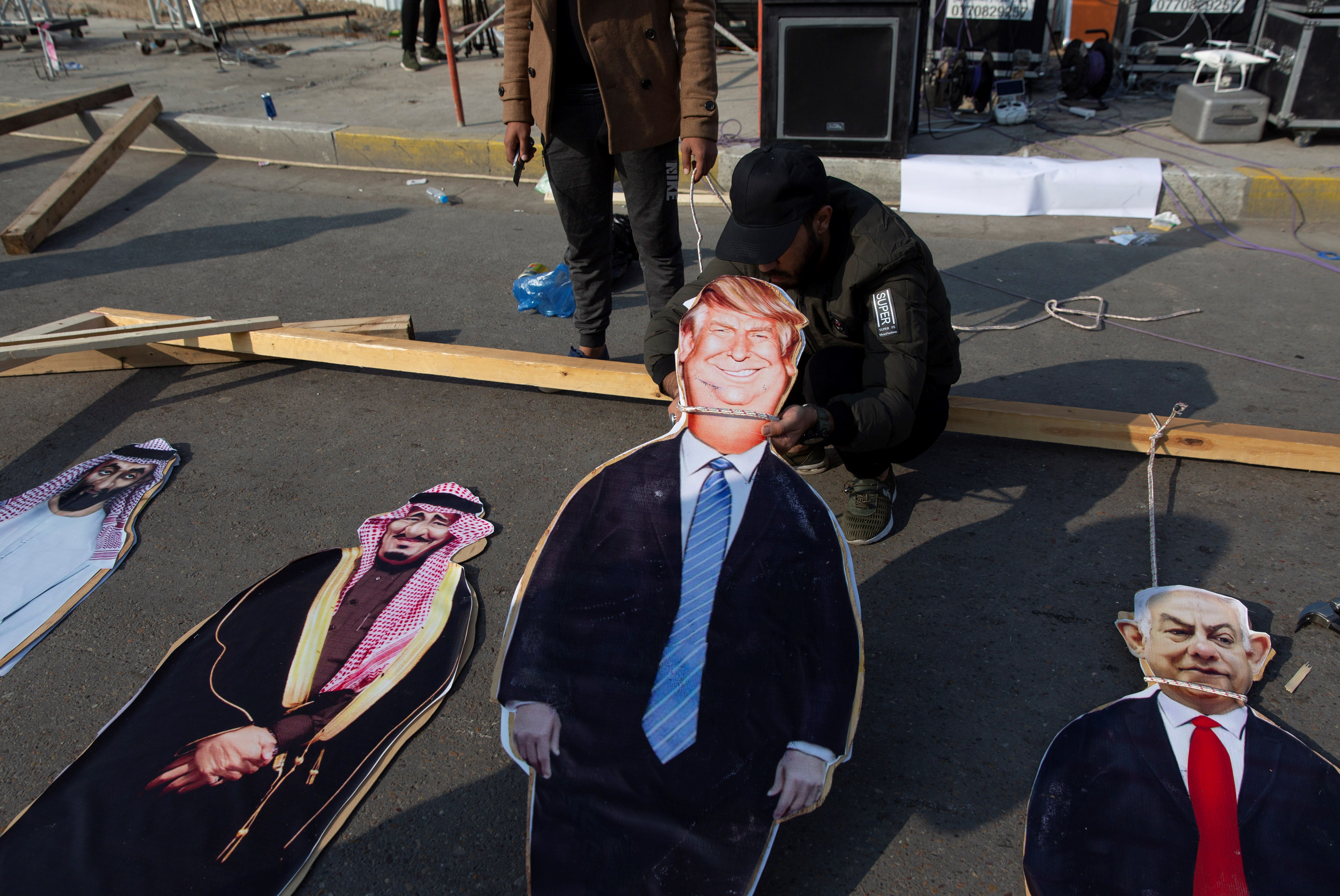 Activists prepare cardboard cutouts from right, Israeli Prime Minister Benjamin Netanyahu, US President Donald Trump and Saudi Arabia's king Salman bin Abdulaziz, are hung to a gallows, during a rally in Baghdad, Iraq, Saturday, Dec. 14, 2019 (AP).