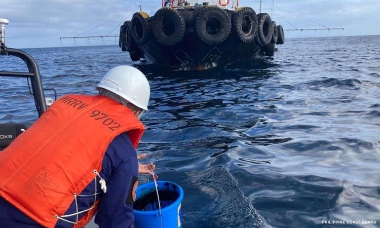 Philippine Coast Guard personnel collect water samples from an oil spill in the waters off Naujan in Oriental Mindoro province after the sinking of a tanker carrying 800,000 litres of industrial fuel oil (AP).