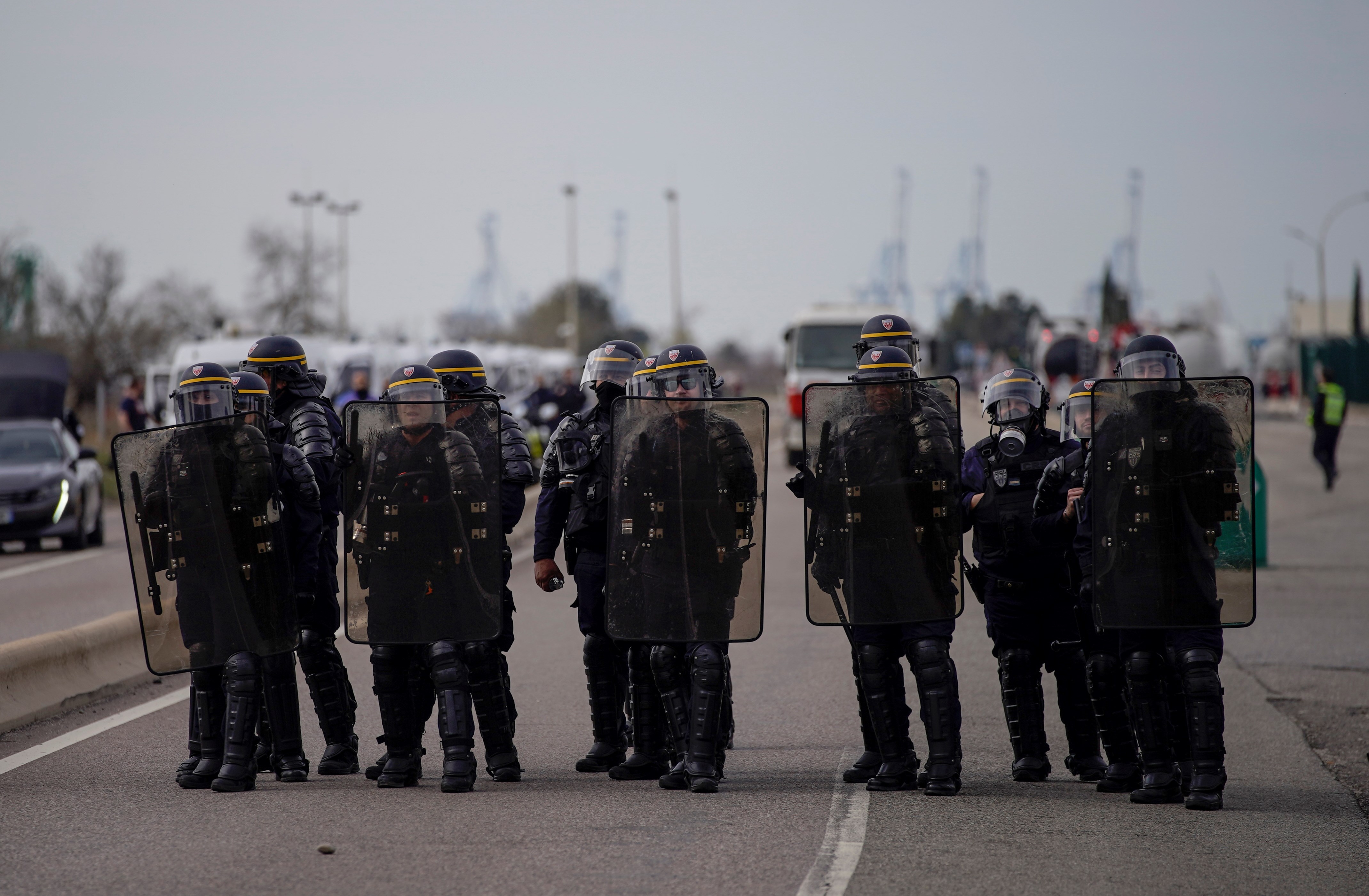 French police officers face oil workers as they block the access to an oil depot in Fos-sur-Mer, southern France, Tuesday, March 21, 2023 (AP Photo/Daniel Cole)