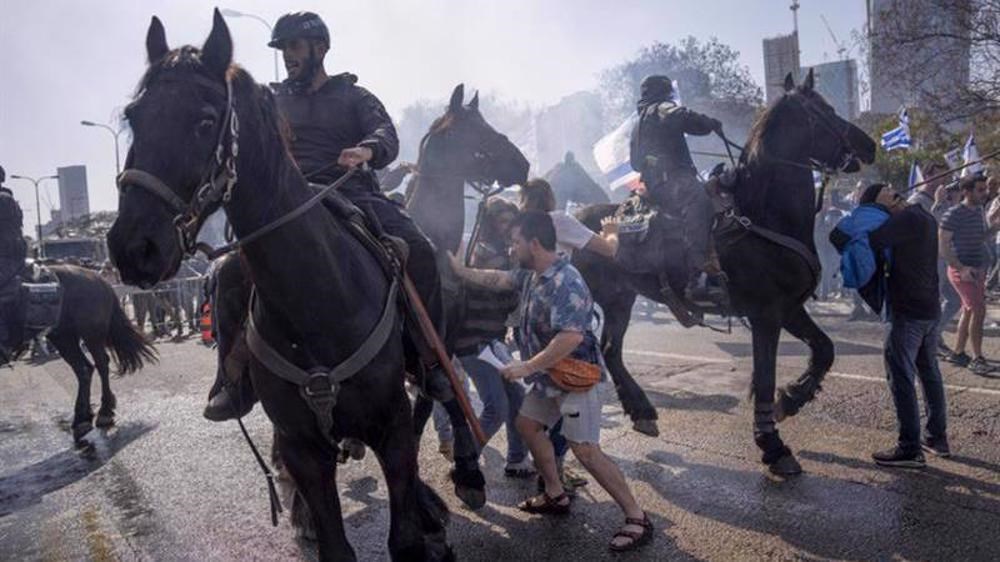 Israeli police deploy horses and stun grenades to disperse protesters blocking a main road in Tel Aviv, March 1, 2023 (AP)