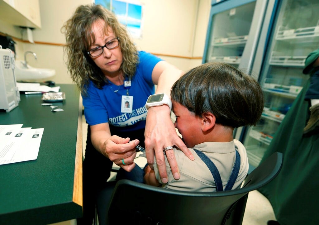 A registered nurse and immunization outreach coordinator with the Knox County Health Department, administers a vaccination to a kid at the facility in Mount Vernon, Ohio, Friday May 17, 2019 (AP Photo/Paul Vernon, File)