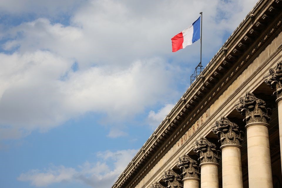 A view shows the French national flag on the top of the Palais Brogniard, former Paris Stock Exchange, located at Place de la Bourse in Paris, France, March 9, 2022. (Reuters)