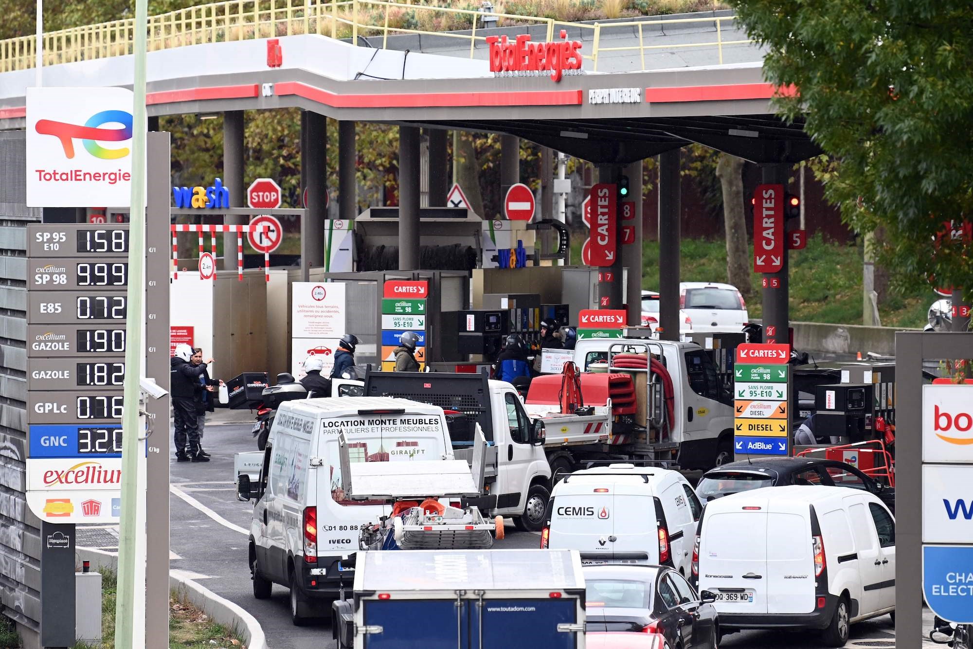 Cars and motorcycles queue for fuel at a gas station in Paris on October 13, 2022 (AFP)