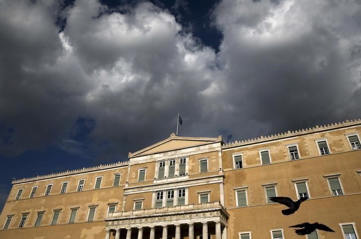 A Greek national flag flutters atop the parliament building in Athens, Greece. (Reuters)