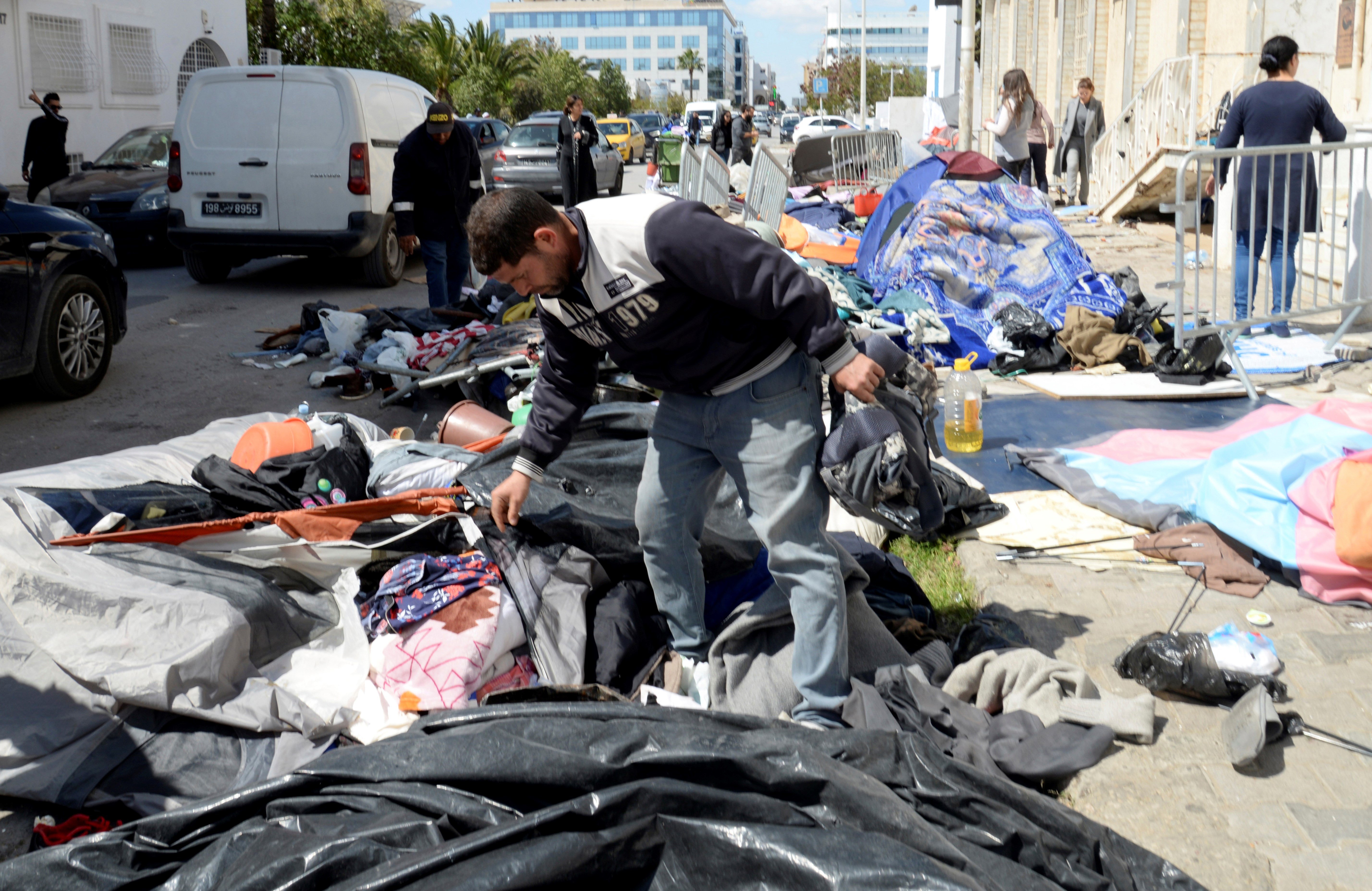 Municipality workers start cleaning a makeshift camp outside the International Organization for Migration office after police forces attempt to evacuate the camp in Tunis, Tuesday, April 11, 2023. (AP)