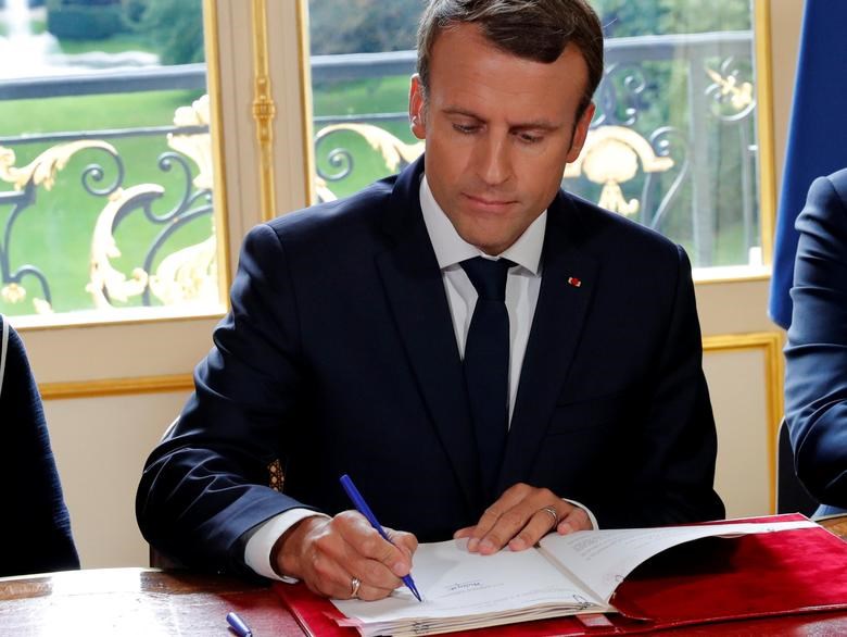 French President Emmanuel signs documents that will promulgate a new labor bill in hiss office at the Elysee Palace, Paris, France, 22 September 2017. (Reuters)