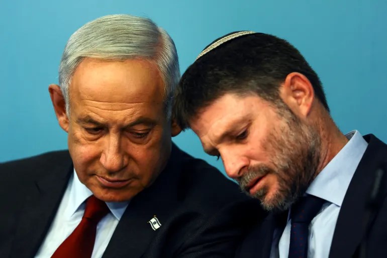 The Occupation's Finance Minister, Bezalel Smotrich talks his Prime Minister Benjamin Netanyahu at a press conference at the Prime Minister's office in occupied Al-Quds, 25 January 2023. (Reuters)