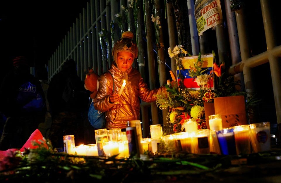 A migrant child from Venezuela lights a candle to cemmorate the lives of the 40 migrants that died at the Natinal Inistitute for Migration (INM) in Ciudad Juarez, Mexico, 28 March 2023. (Reuters)