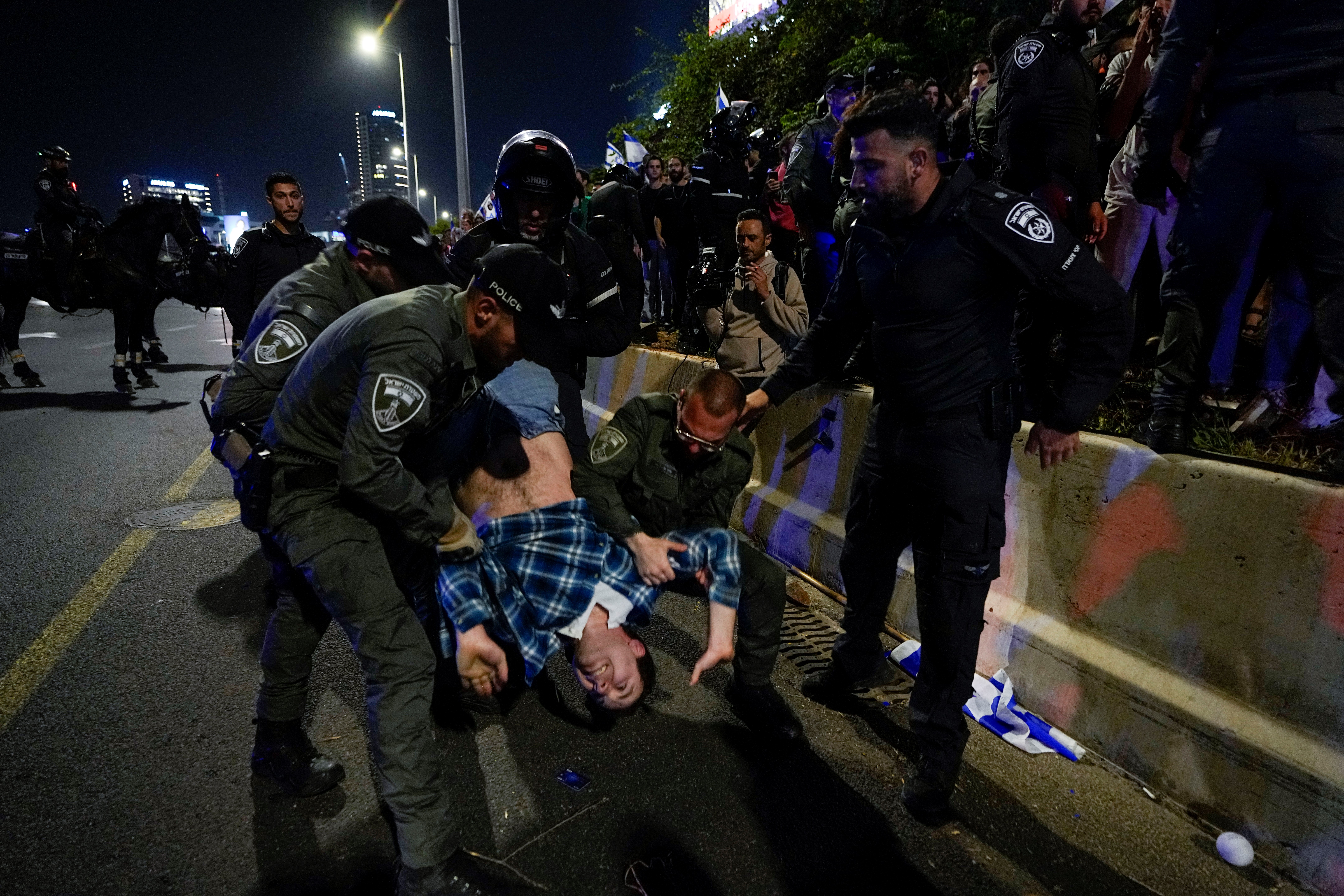 Israeli Occupation Forces disperse demonstrators blocking a highway during protest against plans by Prime Minister Benjamin Netanyahu's government to overhaul the judicial system in Al-Quds, Saturday, April 15, 2023. (AP)