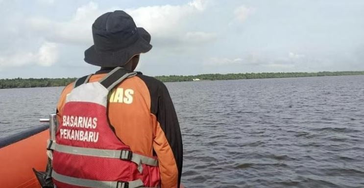 A rescuer scans the horizon during the search for victims of a sinking speedboat in Indragiri Hilir Regency, Indonesia. ( AP)