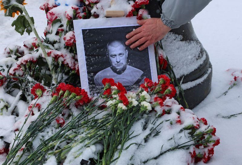 A portrait of Vladlen Tatarsky, who was assassinated in a cafe, is placed near the blast site with flowers in Saint Petersburg, Russia, 3 April 2023. (Reuters)