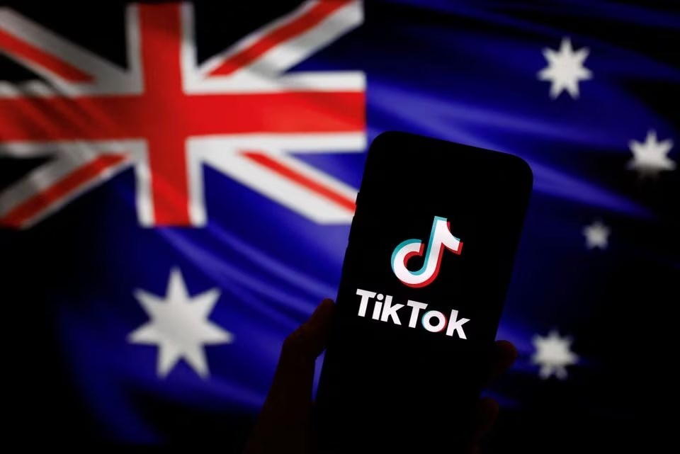 Logo of the Chinese app TikTok displayed on a phone in front of the Australian flag, 4 April 2023. (Reuters)