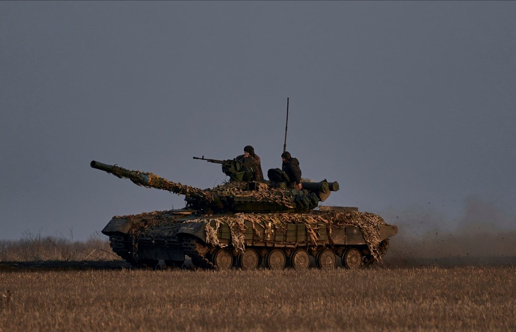 Ukrainian soldiers ride atop a tank on the frontline in Bakhmut, Donetsk region, Wednesday, March 22, 2023 (AP Photo/Libkos)