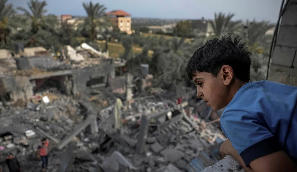 A Palestinian child watches the severe damage inflicted by an Israeli strike on a residential building in Gaza on May 12, 2023. (AFP)