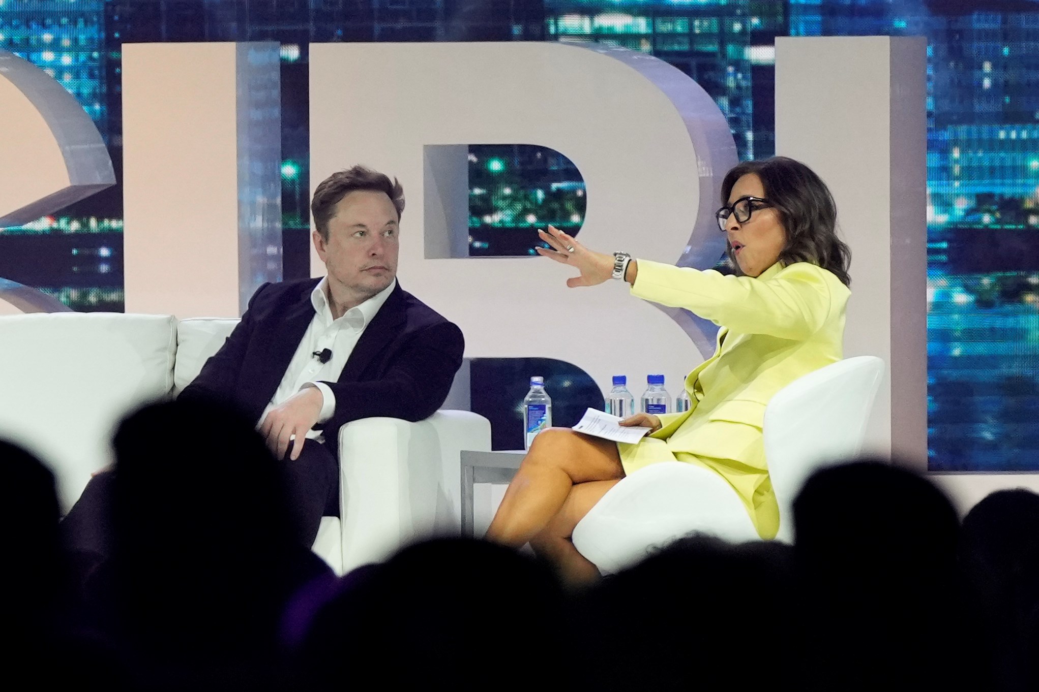 Twitter CEO Elon Musk, center, speaks with Linda Yaccarino, chairman of global advertising and partnerships for NBC, at the POSSIBLE marketing conference, Tuesday, April 18, 2023, in Miami Beach, Florida. (AP)