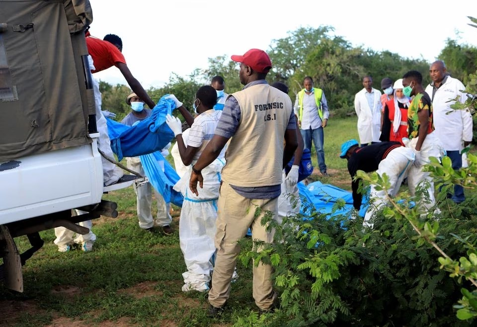 Search and rescue teams alongside homicide detectives from the Directrorate of Criminal Investigations move exhumed bodies into a truck in Shakahola forest, Kilifi, Kenya, 11 May 2023. (Reuters)