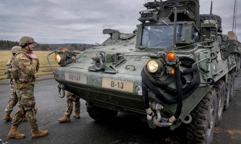 Soldiers of the 2nd Cavalry Regiment stand next to a Stryker combat vehicle in Vilseck, Germany, Wednesday, Feb. 9, 2022 (AP Photo/Michael Probst, File)