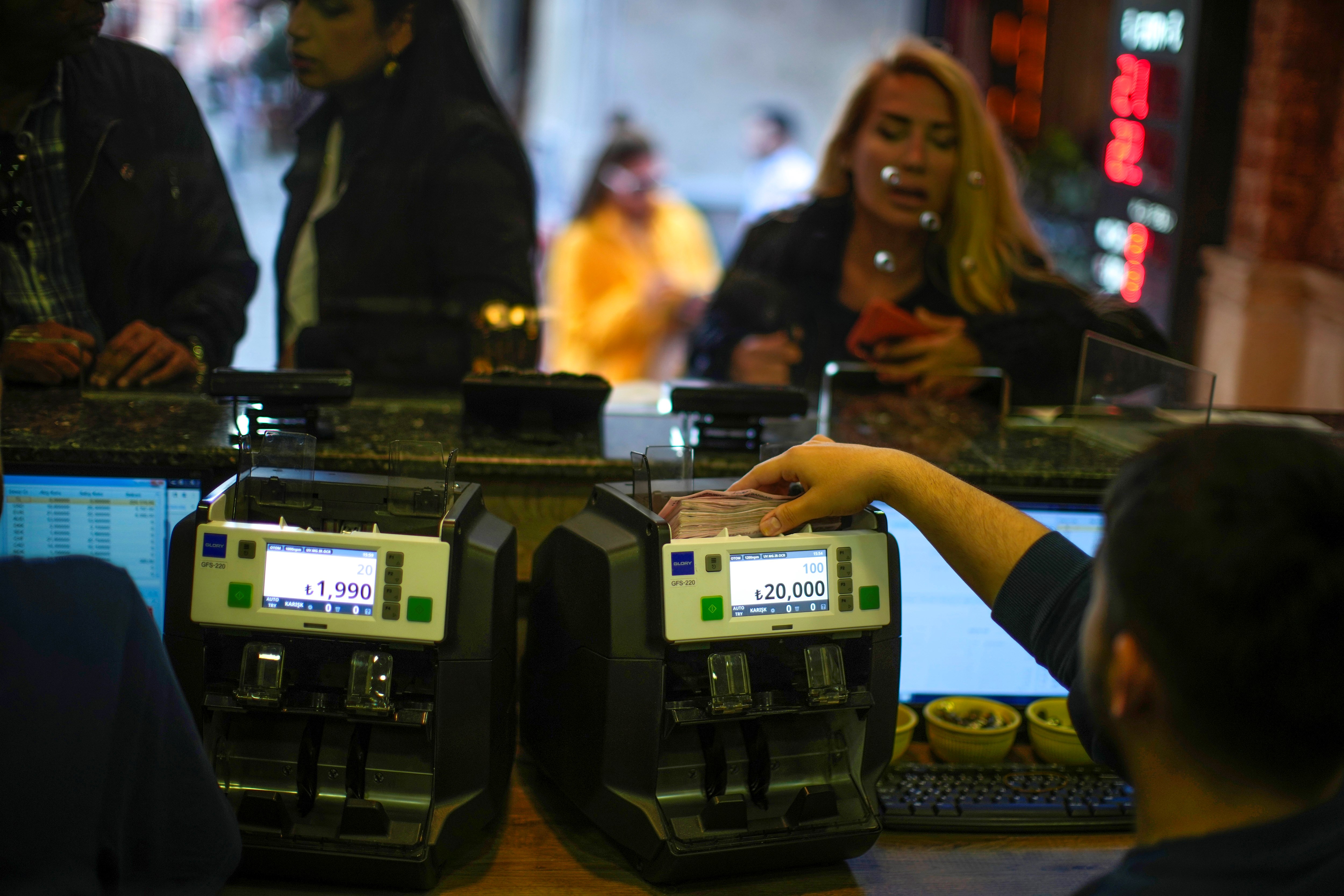 A worker counts Turkish liras banknotes in an exchange currency shop in Istanbul, Turkey, Tuesday, May 2, 2023. (AP)