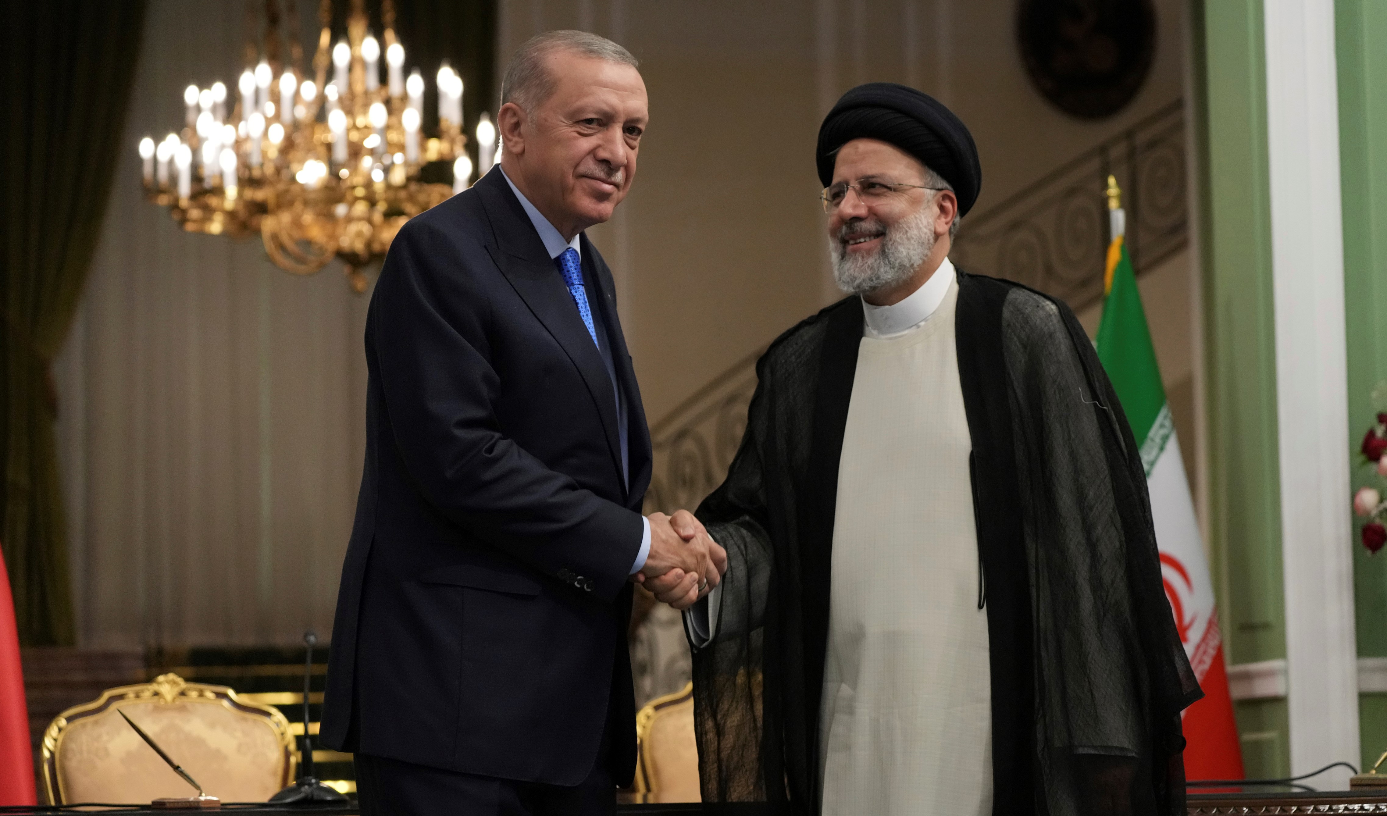 Turkish President Recep Tayyip Erdogan, left, and his Iranian counterpart Ebrahim Raisi shake hands at the conclusion of their joint press briefing at the Saadabad Palace, in Tehran, Iran, Tuesday, July 19, 2022. (AP)