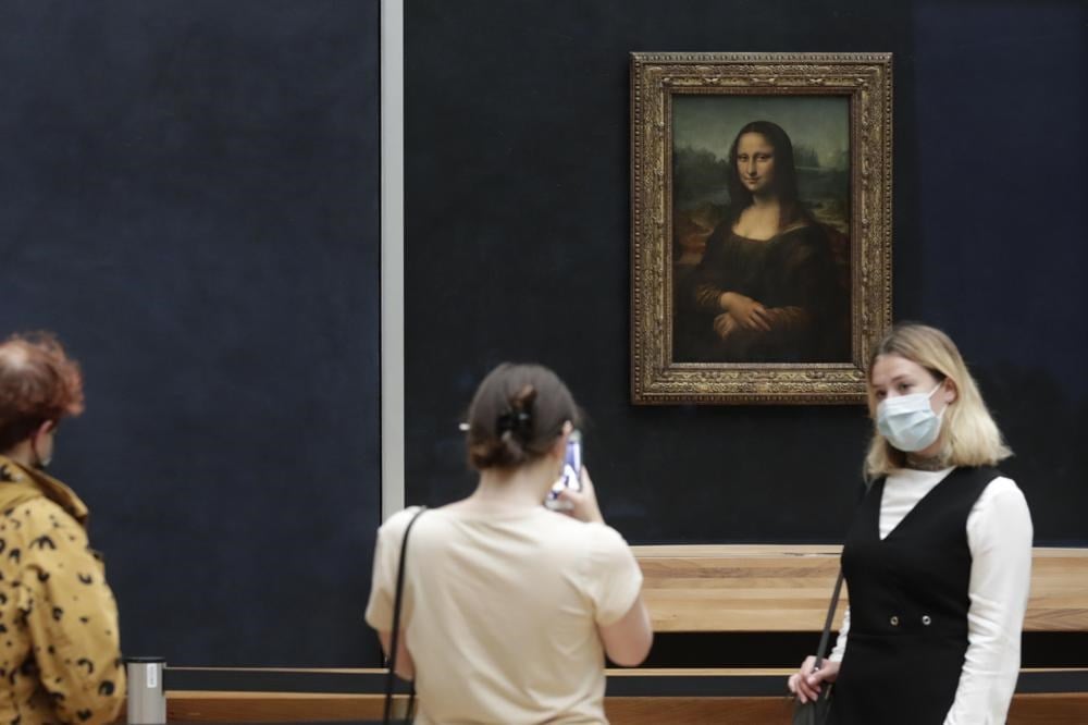 Visitors pose in front of Leonardo da Vinci's Mona Lisa in the Louvre museum, Wednesday, May, 19, 2021 in Paris. (AP)