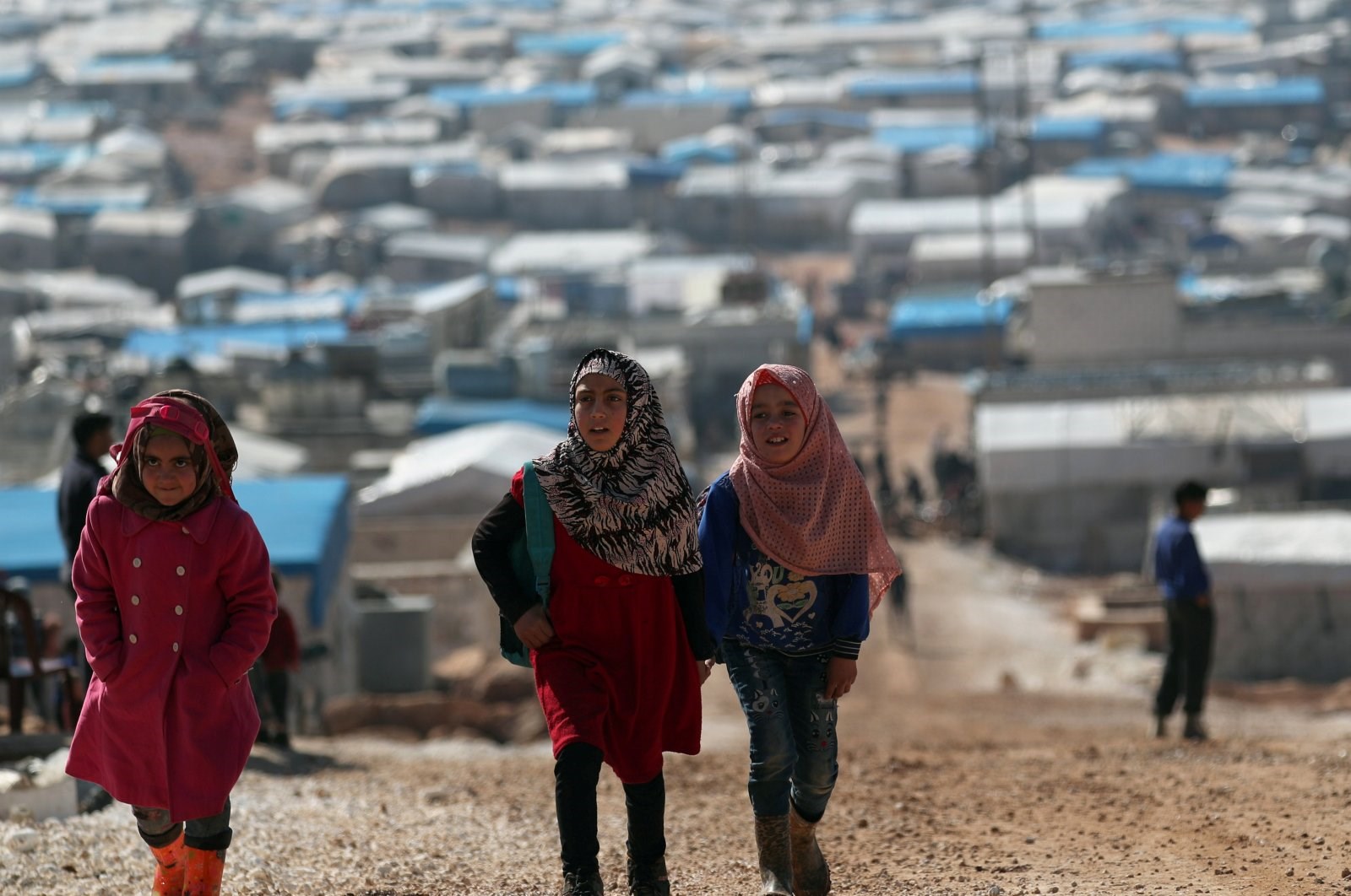 Internally displaced Syrian students walk together in Atmeh IDP camp, located near the border with Turkey, Syria, March 4, 2020. (Reuters)
