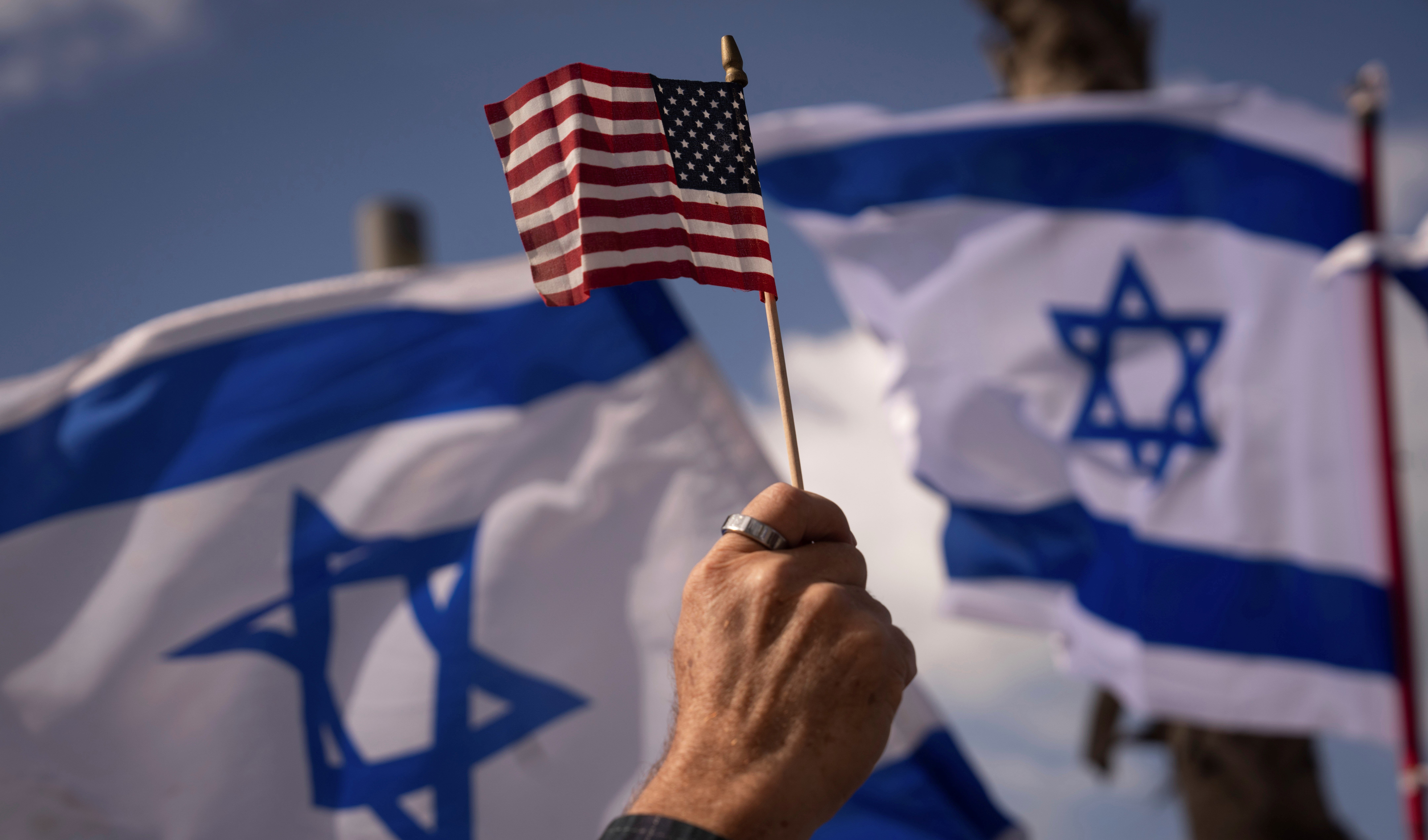 Israeli and US flags during a protest in support of US President Joe Biden, who criticized the plan this week, outside of the US Embassy Branch Office in 'Tel Aviv', occupied Palestine, Thursday, March 30, 2023. (AP)