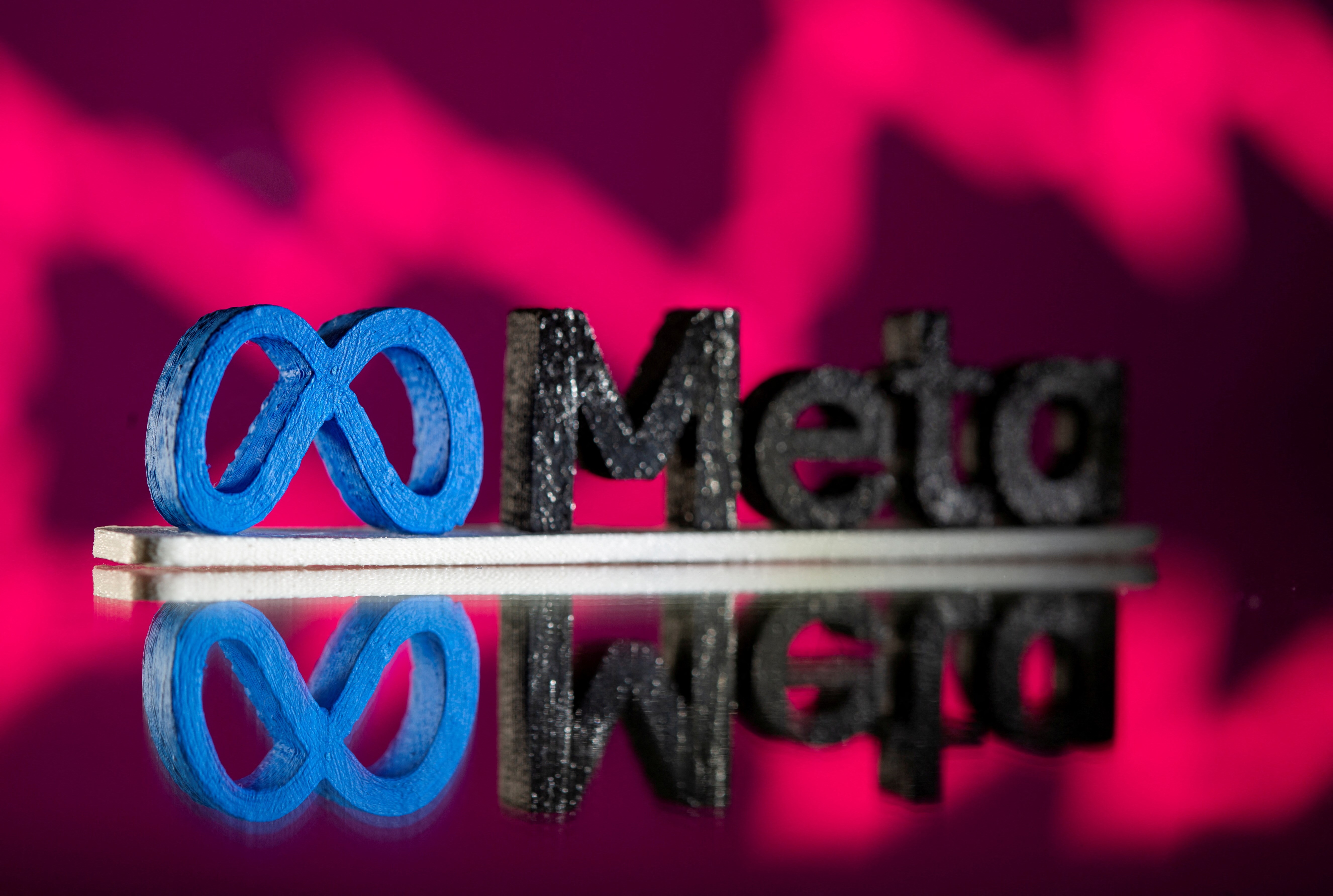 A 3D printed Meta logo is placed in front of a stock graph, November 2 2021. (Reuters)