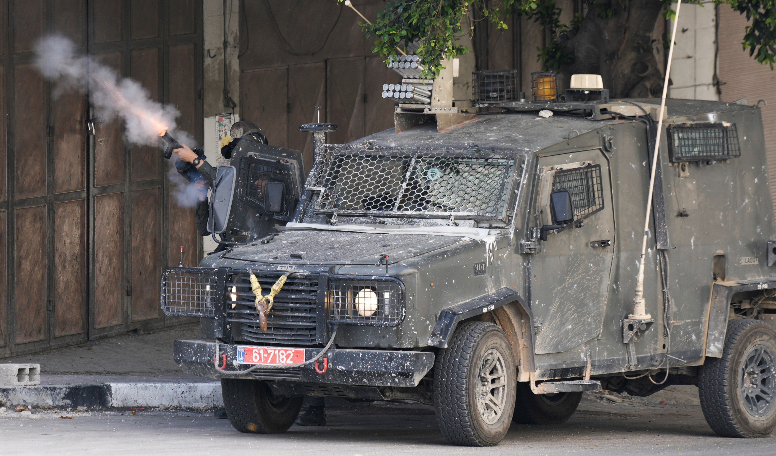 An Israeli border police officer fires tear gas towards Palestinian protesters during an Israeli army raid in the Balata refugee camp near the West Bank town of Nablus, Saturday, May 13, 2023. (AP)