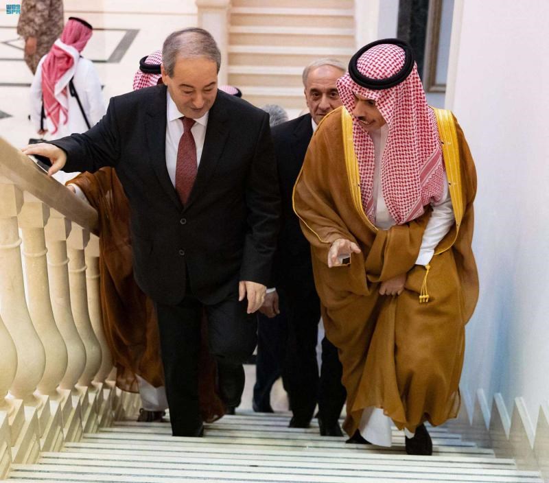 Syrian Foreign Minister Faisal Mekdad (L) walks up a stairway with Saudi Foreign Minister Prince Faisal bin Farhan (R) in Jeddah, April 12, 2023. (AFP)