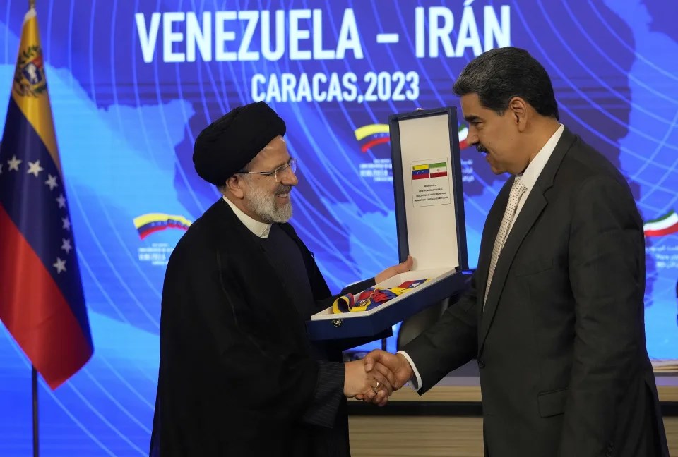 Iranian President Ebrahim Raisi shakes hands with Venezuelan President Nicolas Maduro after receiving the oRder of Libertador y Libertardora de Primera Clase, at the Miraflores Presidential Palace in Caracas, Venezuela, June 12 2023. (AP)