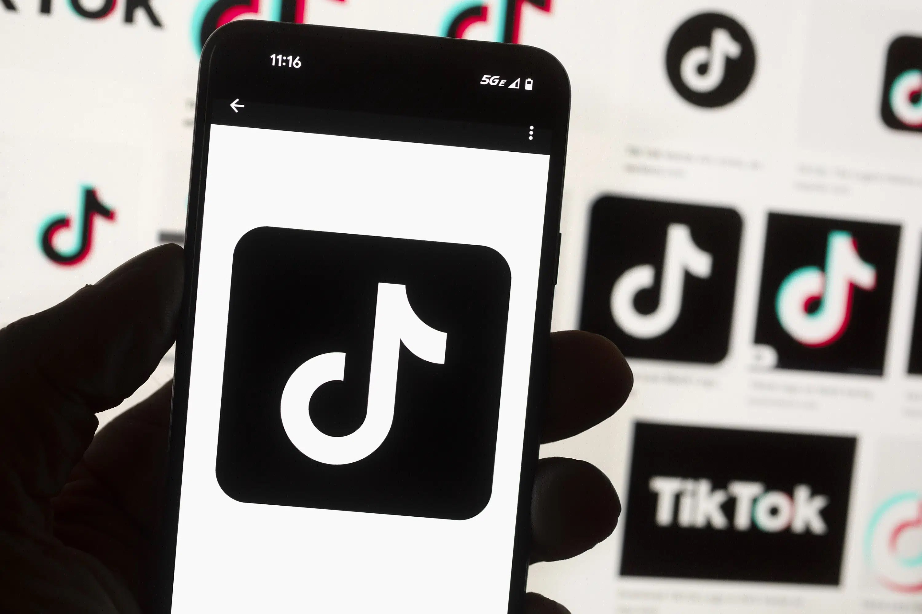 The TikTok logo is displayed on a smart phone held in front of multiple logos, Boston, US, October 14 2022. (AP)