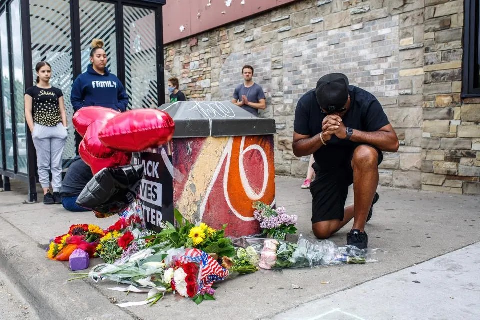 A protester prays in front of the memorial of George Floyd in 2020 (AFP via Getty Images)