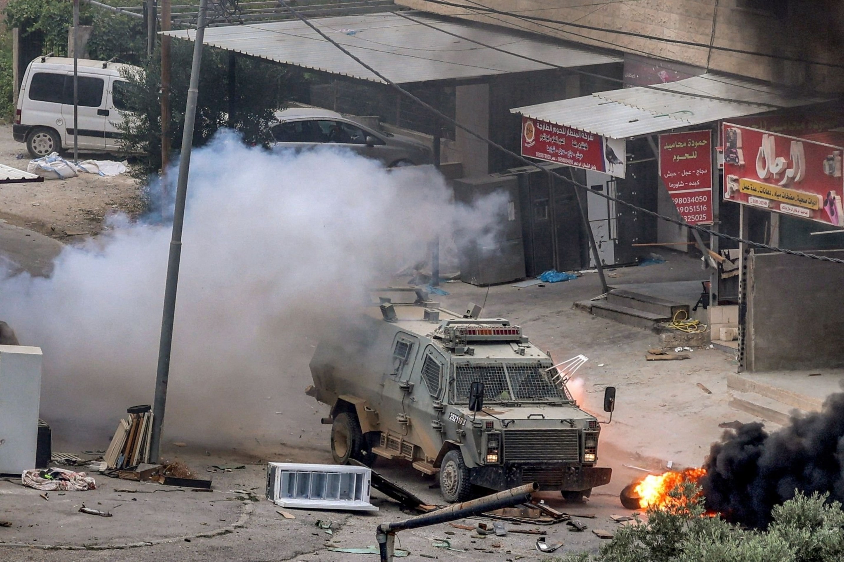 An explosive device detonates next to an Israeli armoured vehicle after the Israeli occupation forces raided Jenin in the occupied West Bank, Palestine, June 19 2023. (AFP)