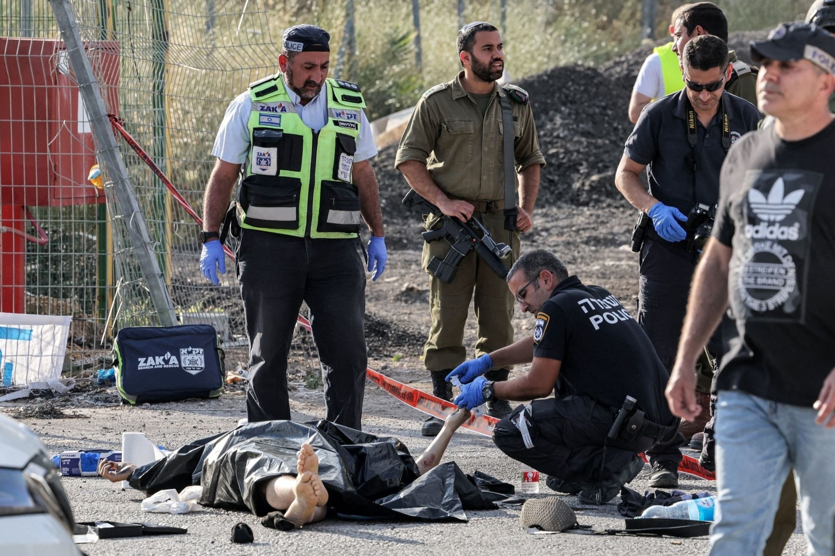 Occupation police and forensics experts inspect a dead body at the site of shooting carried out by Palestinian Fida'is near the settlement of 'Eli', occupied West Bank, Palestine, June 20 2023. (AFP)