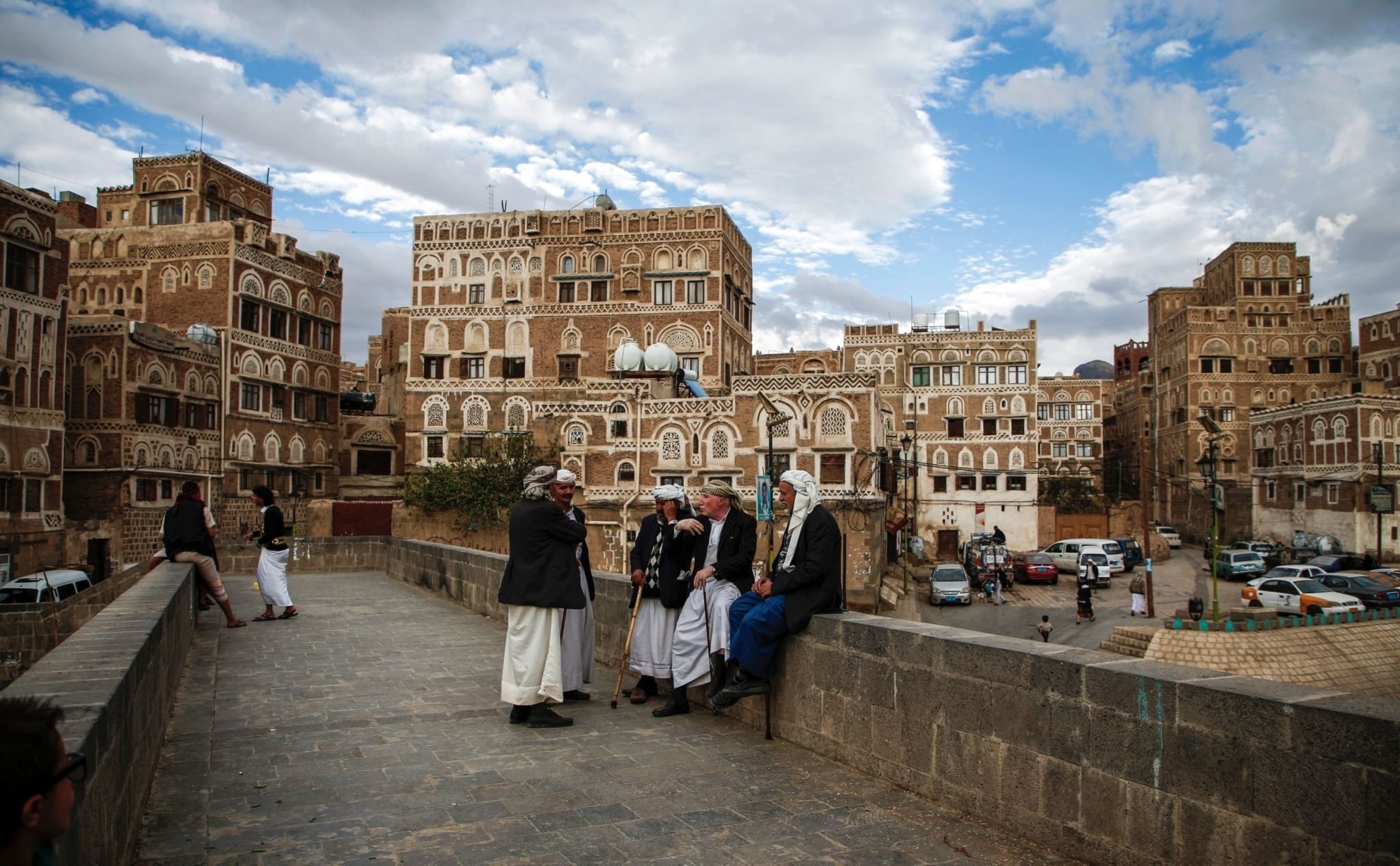 Locals sit and chat by the ledge of a bridge leading to UNESCO-listed buildings in the old city of Sanaa, Yemen, February 15 2017. (AFP)