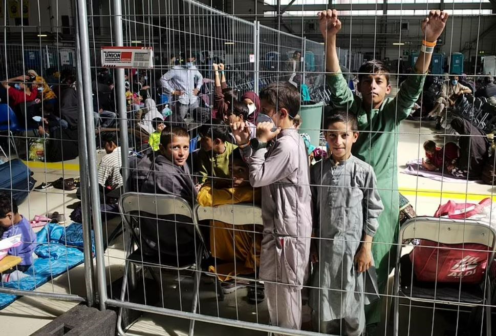 Children and other Afghan refugees wait inside a makeshift departure gate inside a hangar at Ramstein Air Base. (AP)