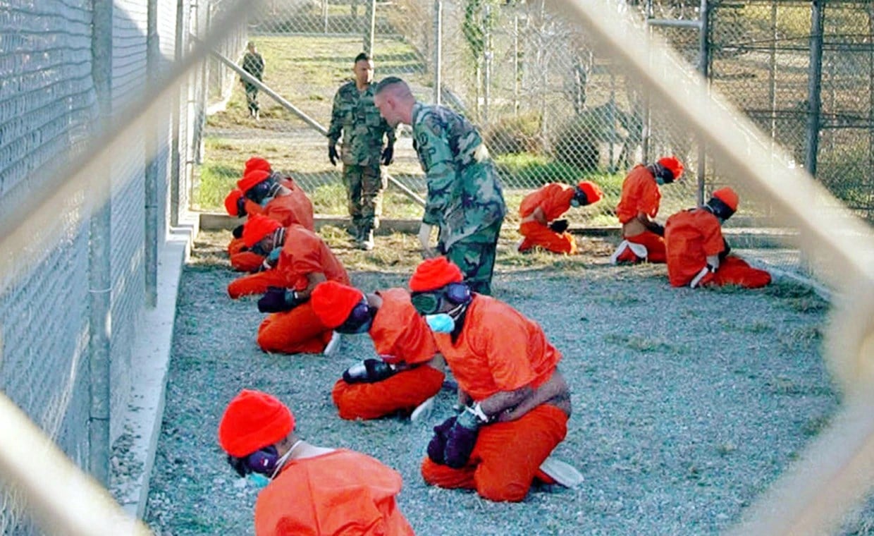 Detainees sit in a holding area at the US Navy base at Guantanamo Bay, Cuba, during in-processing to the temporary detention facility on Jan. 11, 2002. (AP)