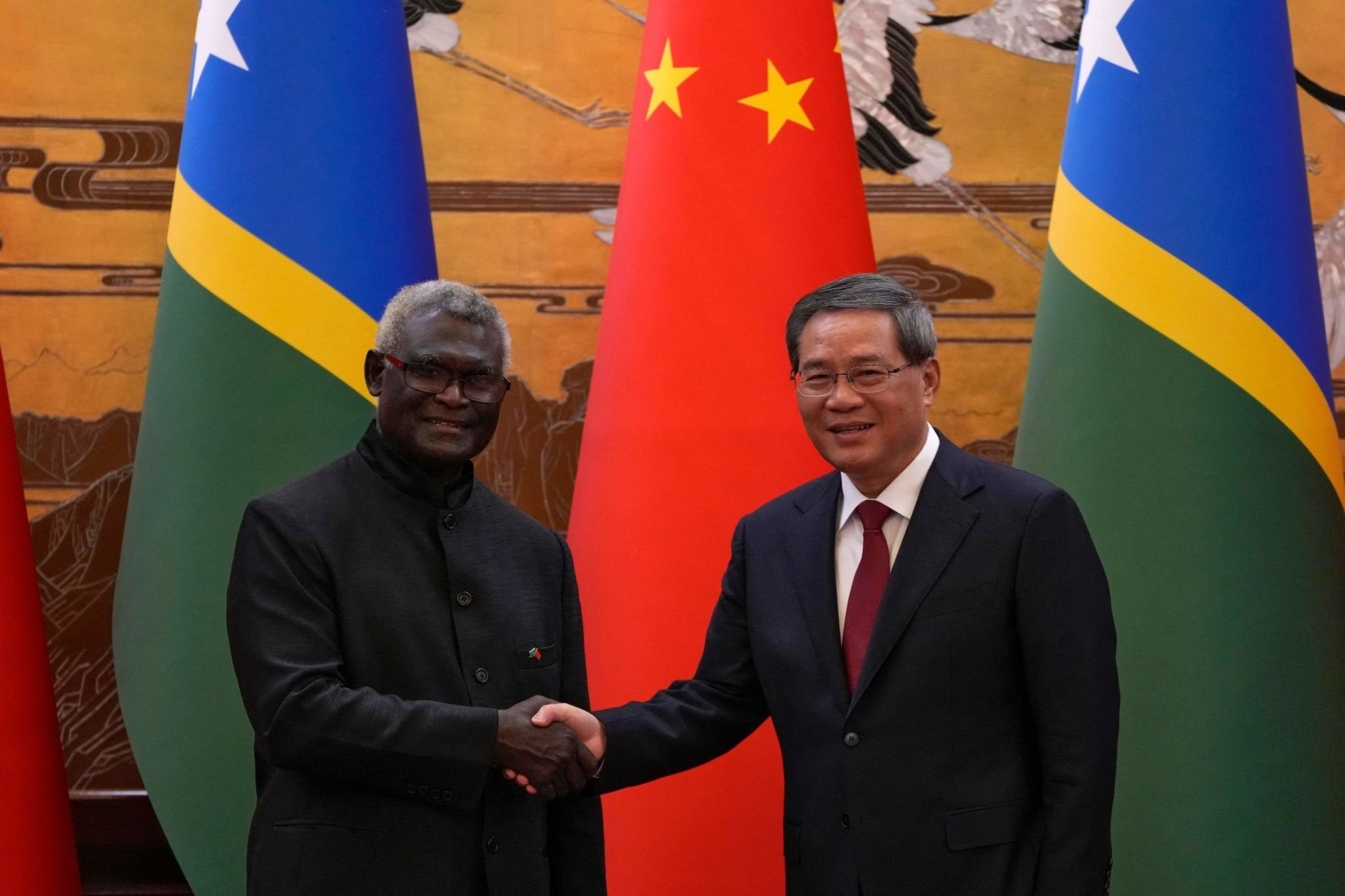 Solomon Islands' Prime Minister Manasseh Sogavare hakes hands with China's Premier Li Qiang after signing a number of agreements at the Great Hall of the People in Beijing, China, July 10 2023. (AFP)