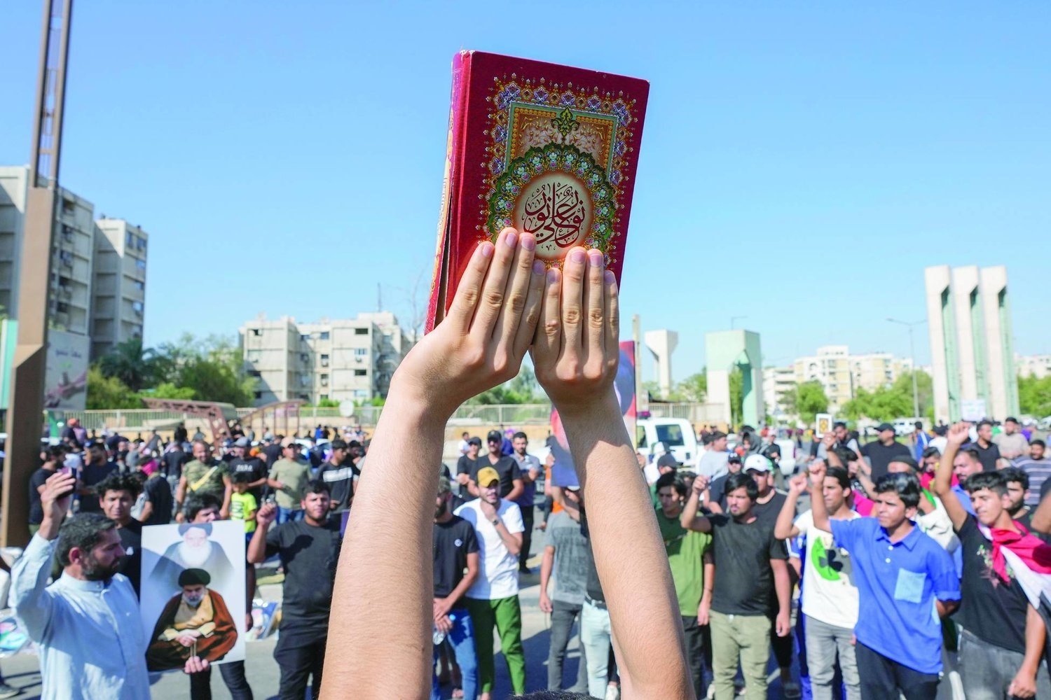 Supporters of the Shiite cleric Muqtada al-Sadr raises of the Quran, the Muslims' holy book, during a demonstration in front of the Swedish embassy in Baghdad in response to the burning of Quran in Sweden, Baghdad, Iraq, Friday, June 30, 2023. (AP)