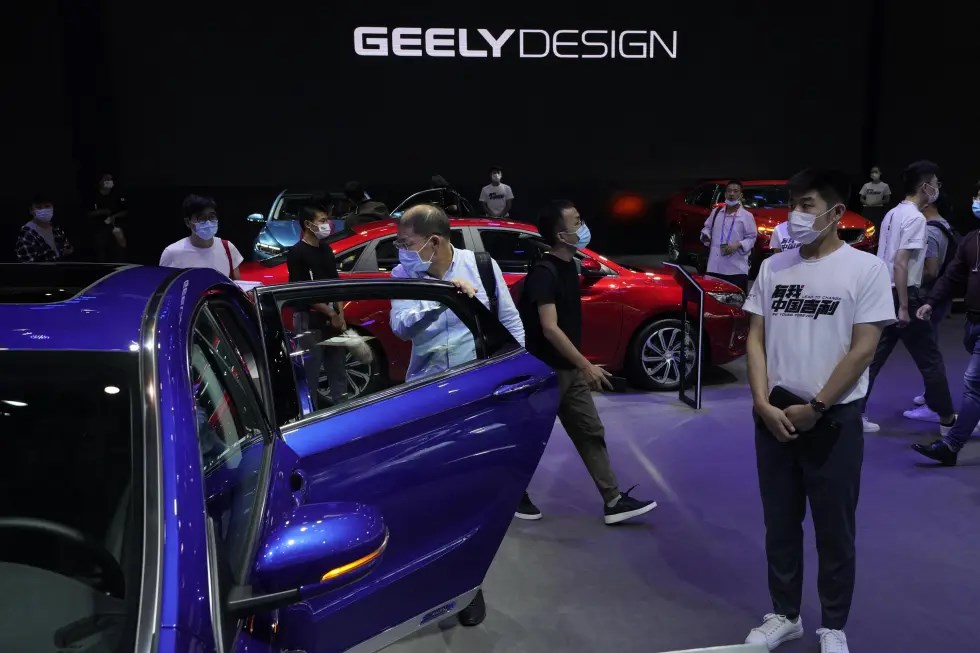 FILE - Visitors look at cars produced by Geely at the Auto China 2020 show in Beijing on Sept. 27, 2020 (AP)