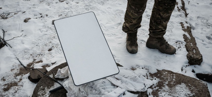 A Ukrainian serviceman stands next to the antenna of the Starlink satellite-based broadband system in Bakhmut on February 9, 2023. (AFP)
