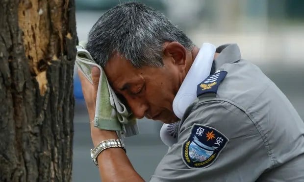A security guard wipes sweat from his forehead in Beijing, China, on 3 July 2023. Photograph: Andy Wong/AP