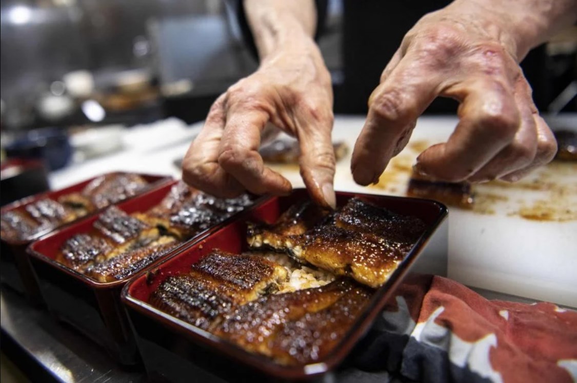 Japanese chef Tsuyoshi Hachisuka prepares grilled eel before serving them to customers at his restaurant in Hamamatsu, Shizuoka prefecture. (AFP)