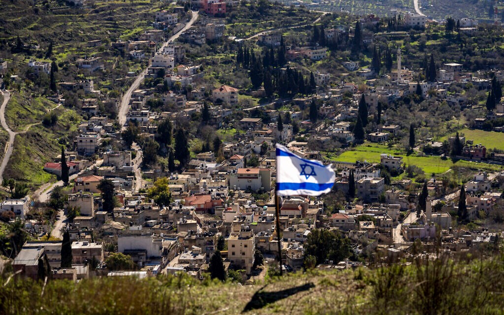 The Palestinian village of Burqa is seen as an Israeli flag is placed in the Jewish West Bank outpost of Homesh, January 17, 2022. (AP)