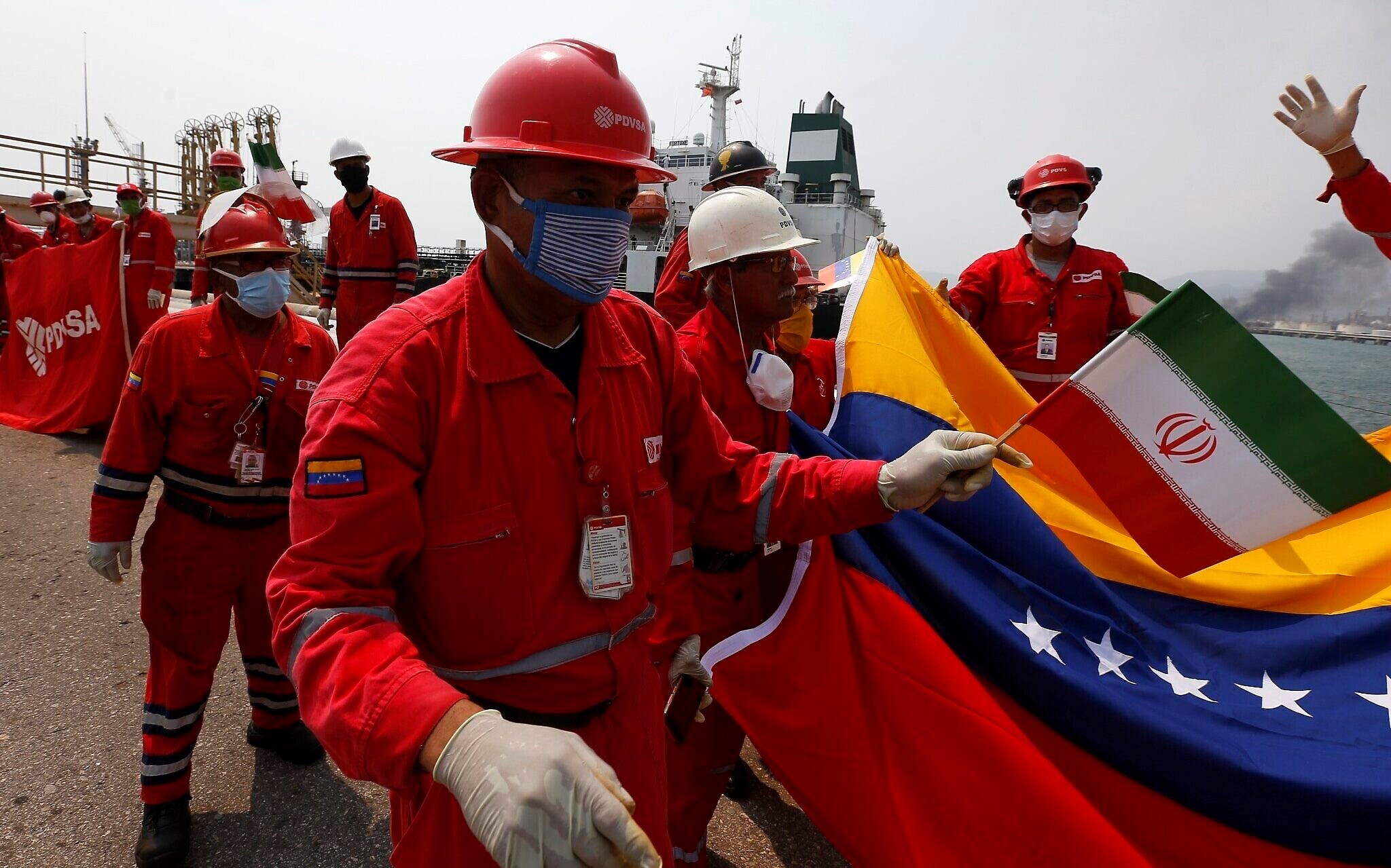 A Venezuelan oil worker holding a small Iranian flag attends a ceremony for the arrival of Iranian oil tanker Fortune at the El Palito refinery near Puerto Cabello, Venezuela on May 25, 2020. (AP)