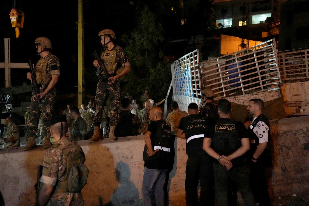 Lebanese soldiers stand guard next to an overturned truck, right, in the Christian town of Kahaleh, Lebanon, Wednesday, Aug. 9, 2023. (AP)