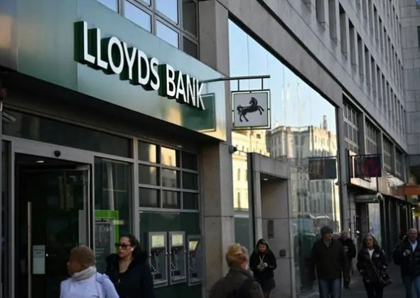 Pedestrians walk past a branch of a Lloyds Bank, in central London, February 14, 2023. (AFP)