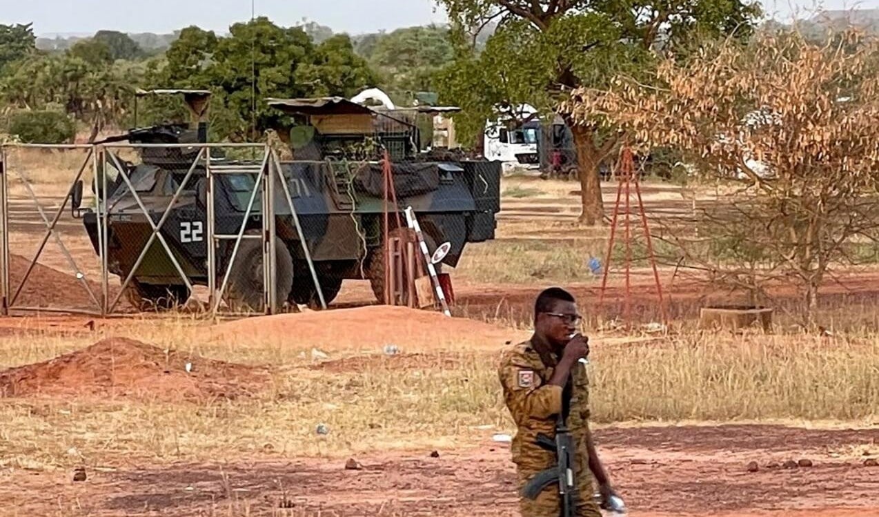 A Burkinabe soldier walks past a French armoured personnel carrier, part of a French military convoy heading to Niger that was stopped by protesters in Kaya, Burkina Faso, on November 20, 2021 (AP)