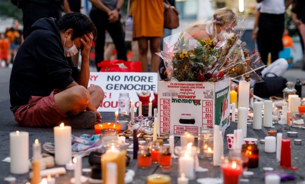 A man holds his head as he attends an impromptu vigil at an anti-Canada Day event titled