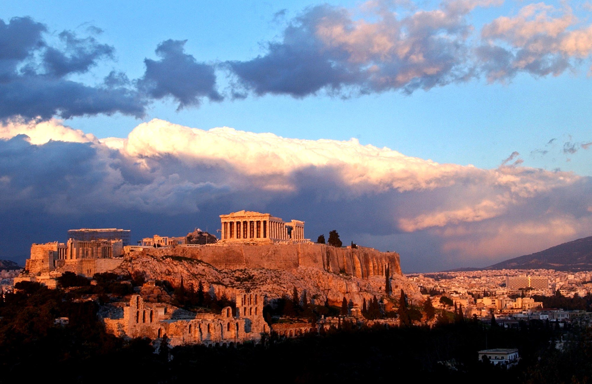Sunlight catches clouds behind the ancient Acropolis in Athens on Tuesday, Feb. 3, 2004. (AP)